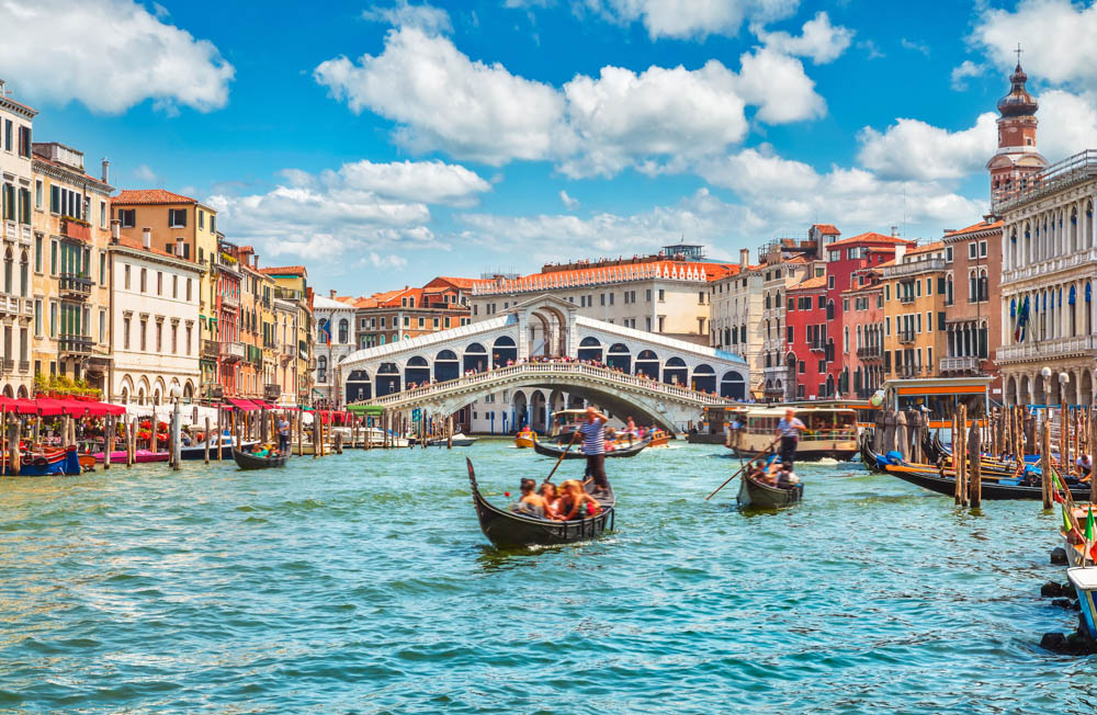 義大利威尼斯 Bridge Rialto on Grand canal famous landmark panoramic view Venice Italy with blue sky white cloud and gondola boat water. 
